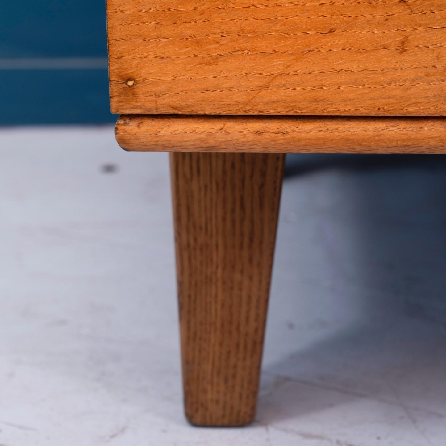 Dettaglio gamba Bancone vetrina inglese in legno di rovere, risalente alla prima meta del '900, con due mensole e ante scorrevoli in vetro.  Riporta la targhetta originale "David S. Butler ltd office equipment specialists Derby".