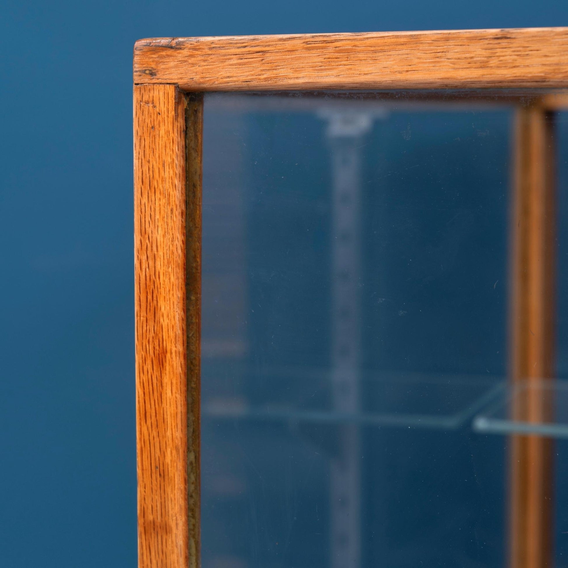 Dettaglio angolo Bancone vetrina inglese in legno di rovere, risalente alla prima meta del '900, con due mensole e ante scorrevoli in vetro.  Riporta la targhetta originale "David S. Butler ltd office equipment specialists Derby".