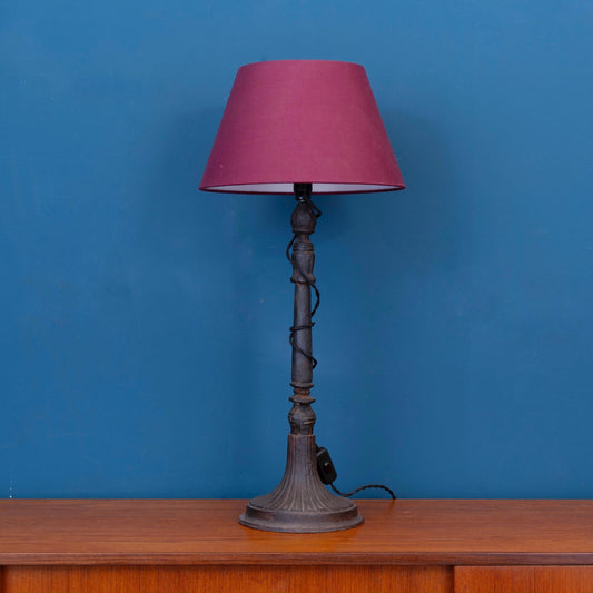 Lampada da tavolo francese in ghisa con paralume conico bordeaux, risalente alla fine dell’800. 