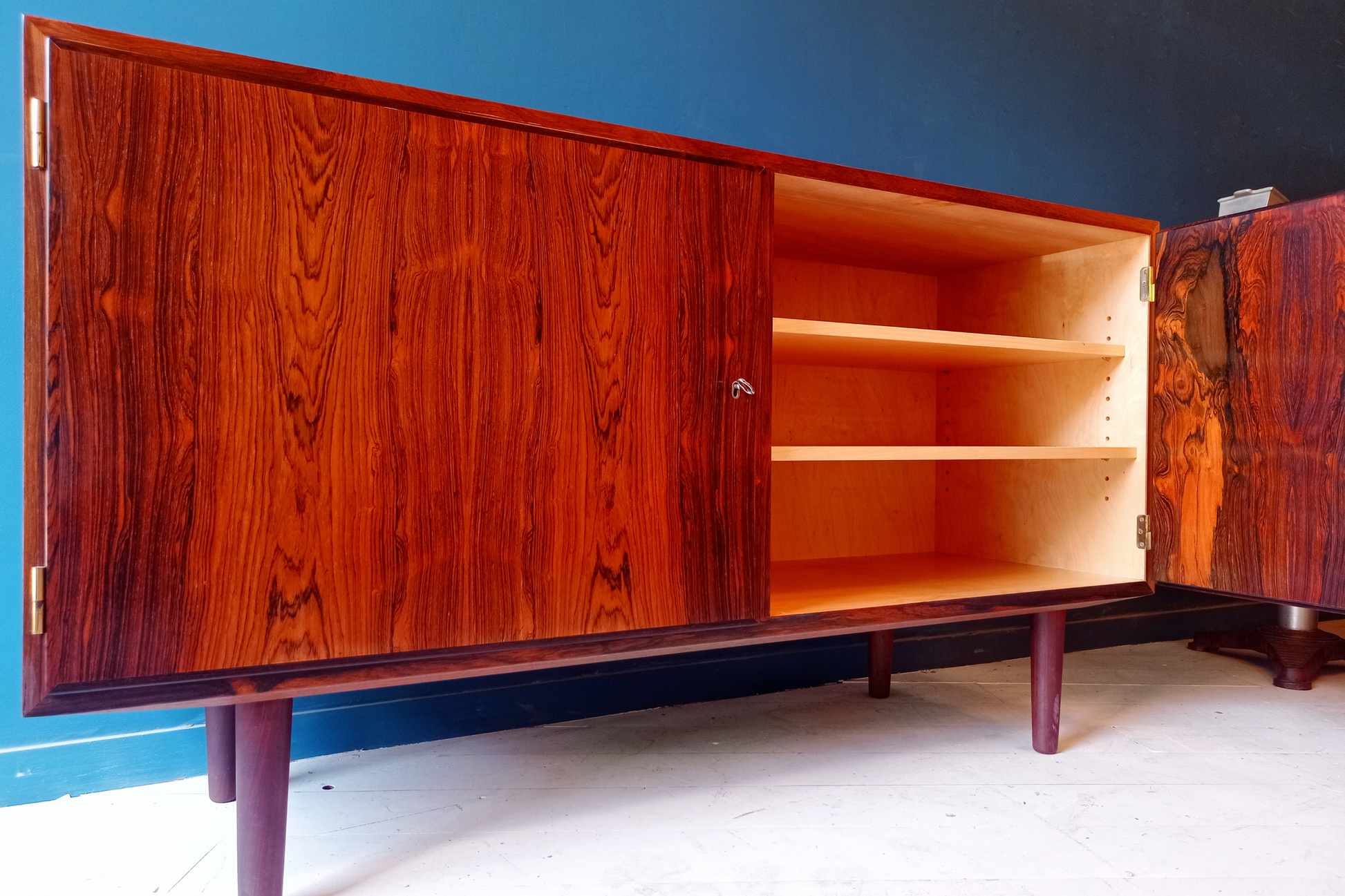 Dettaglio interno sideboard danese in legno di palissandro risalente agli anni '60. Mobile credenza con 2 ante a battente e scaffalatura interna.