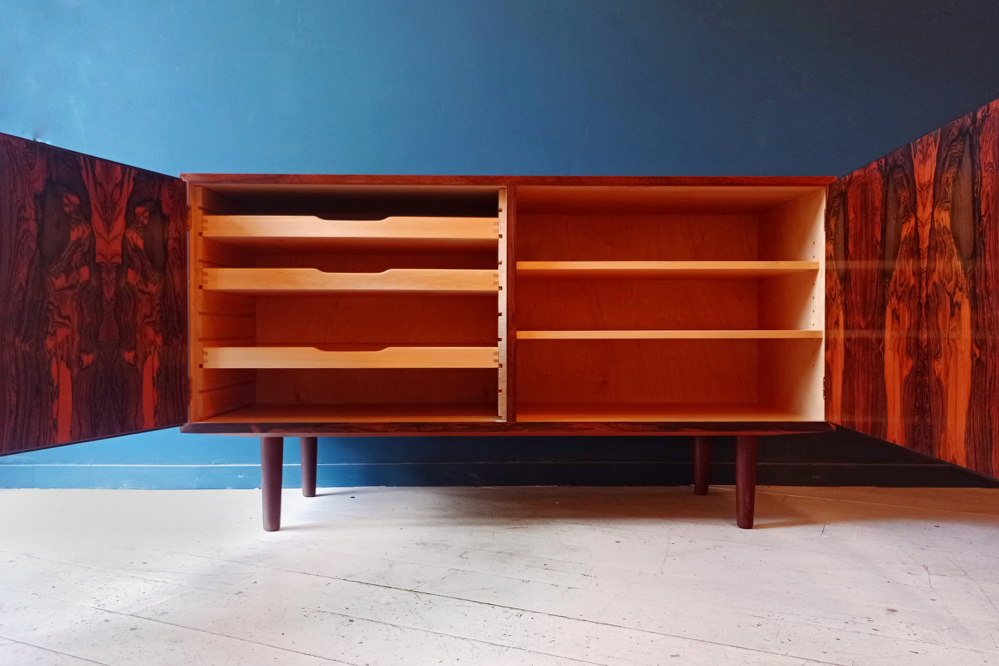 Dettaglio interno sideboard danese in legno di palissandro risalente agli anni '60. Mobile credenza con 2 ante a battente e scaffalatura interna.