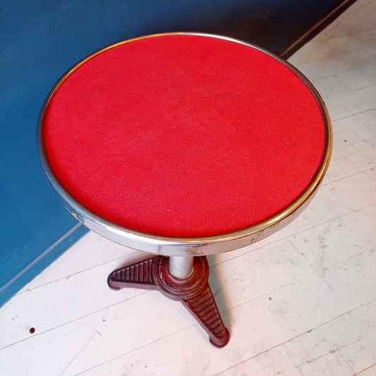 Dettaglio piano tavolino da bistrot francese vintage, risalente agli anni '30. Piano in formica rossa bordata in alluminio, gamba in alluminio e base in ghisa.