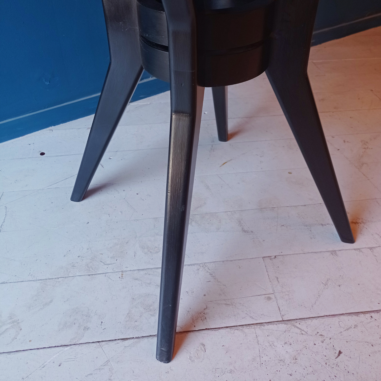Dettaglio gambe tavolo da pranzo tondo vintage in legno rigatino di mogano con gambe ebanizzate, risalente agli anni '50. 